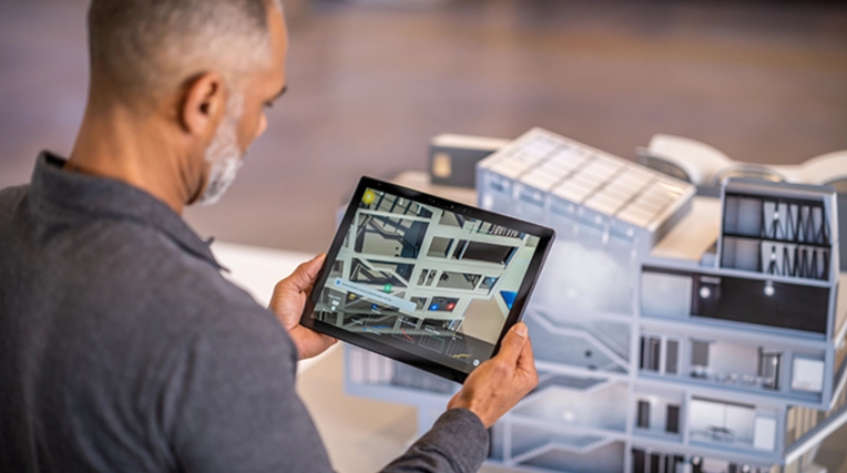 man holding tablet with architecture software displayed